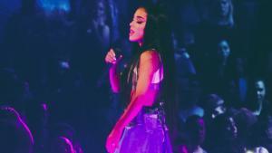 Ariana Grande en rosa canta con mic